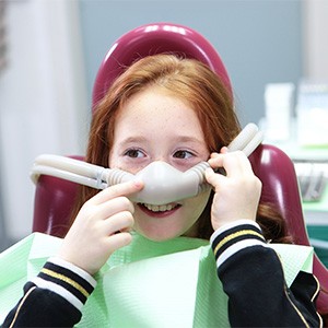 A little girl wearing a nitrous oxide nose mask