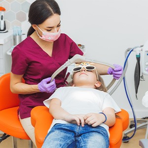 Pediatric dentist taking a nose mask off her patient