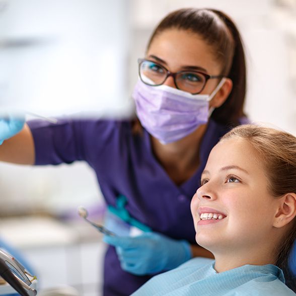 Dental team member talking to young patient