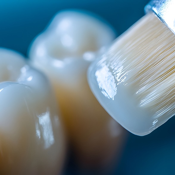 Up-close view of brush applying dental sealants to teeth 