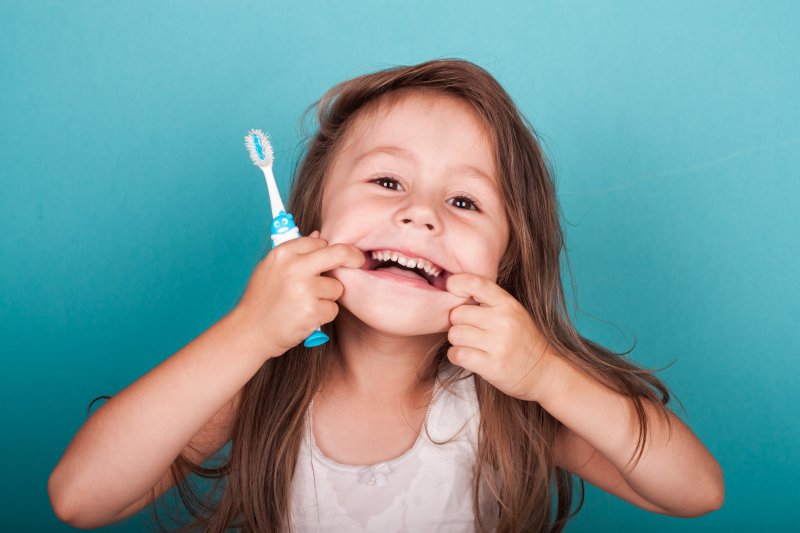 Kid smiles with toothbrush